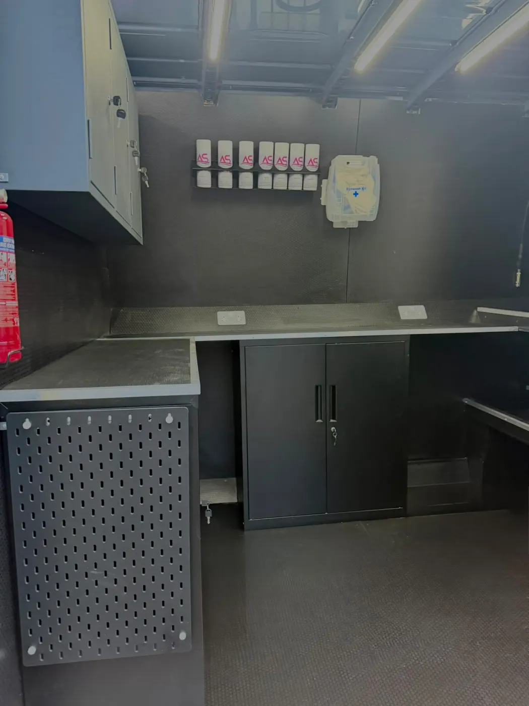 Dark grey workshop cabinets and worktop fitted inside a van